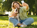 Une femme assise en train de faire un selfie avec son chien.